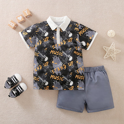 Toddler's outfit with patterned shirt and gray shorts on a beige surface