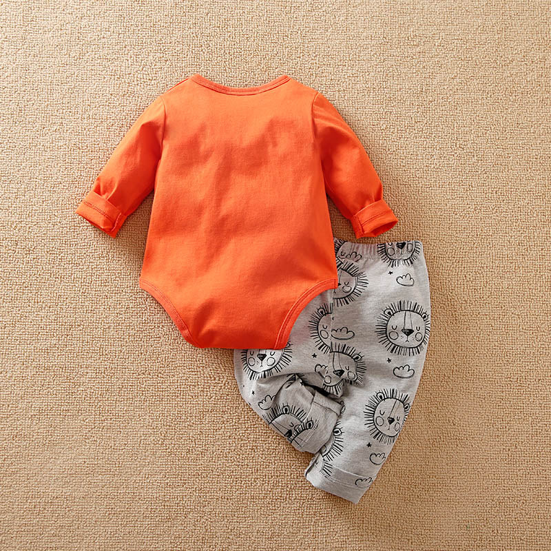 Orange baby bodysuit and gray pants with lion prints on a beige carpet back view