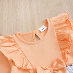 Baby Butterfly Dress Long Sleeve | Hushies Boutique showing peach fabric with ruffled shoulder detail and bow accent on soft baby clothing