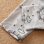 Gray fabric with black line art patterns on a beige surface