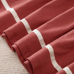 Soft rust-colored cotton fabric with white ribbed stripes folded.