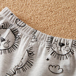 Children's shorts with black sun and cloud patterns on a beige carpet background