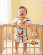 Little Roar Baby Boy Romper on a cheerful toddler standing in a crib, featuring a fun tiger print that adds a playful touch.