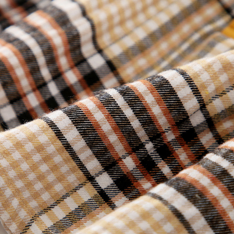 Close-up of plaid fabric with brown, beige, and black colors.