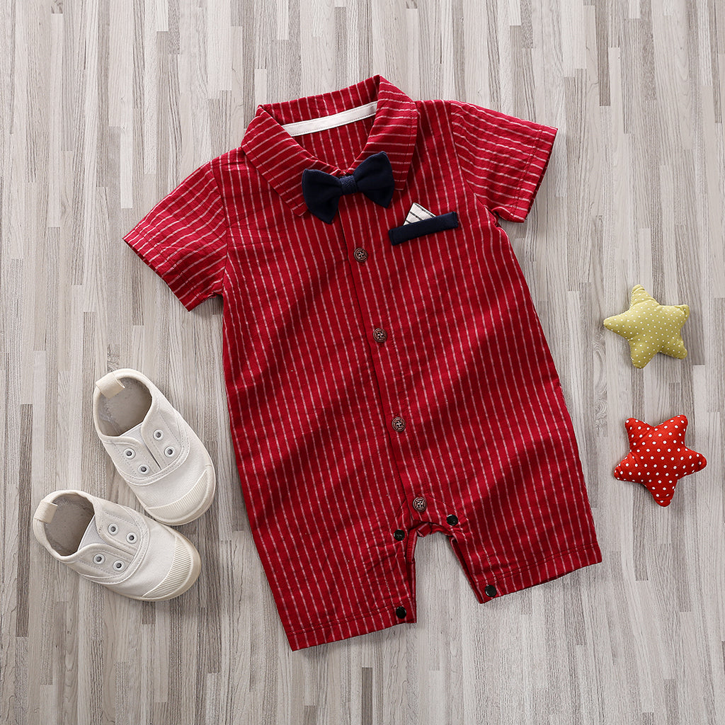 The Adorable 1-Piece Striped Infant Clothing Jumpsuit With Bow Tie & Button-Up Front is displayed with white shoes, plus yellow and red polka-dot star cushions, making a cute ensemble on a wooden floor.