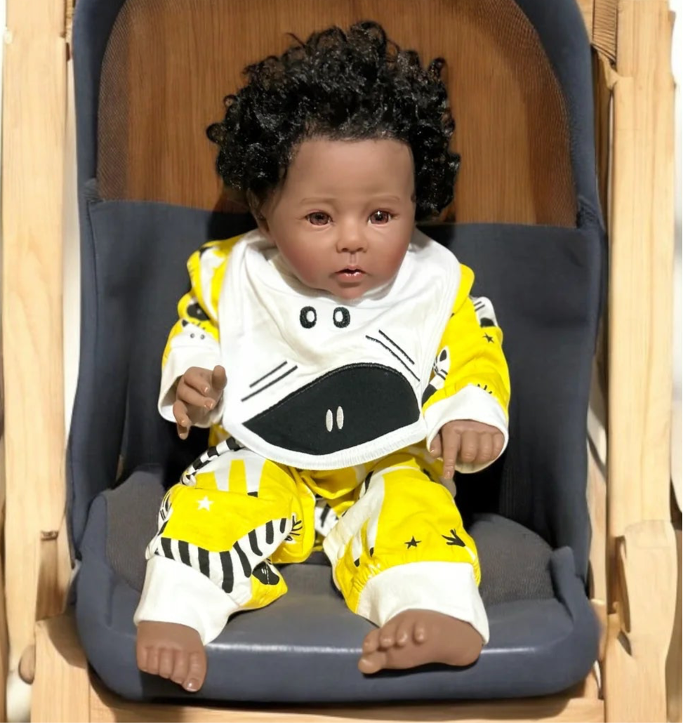 A charming baby doll in a zebra jumpsuit is seated in a chair, with a phone placed on the table beside it.