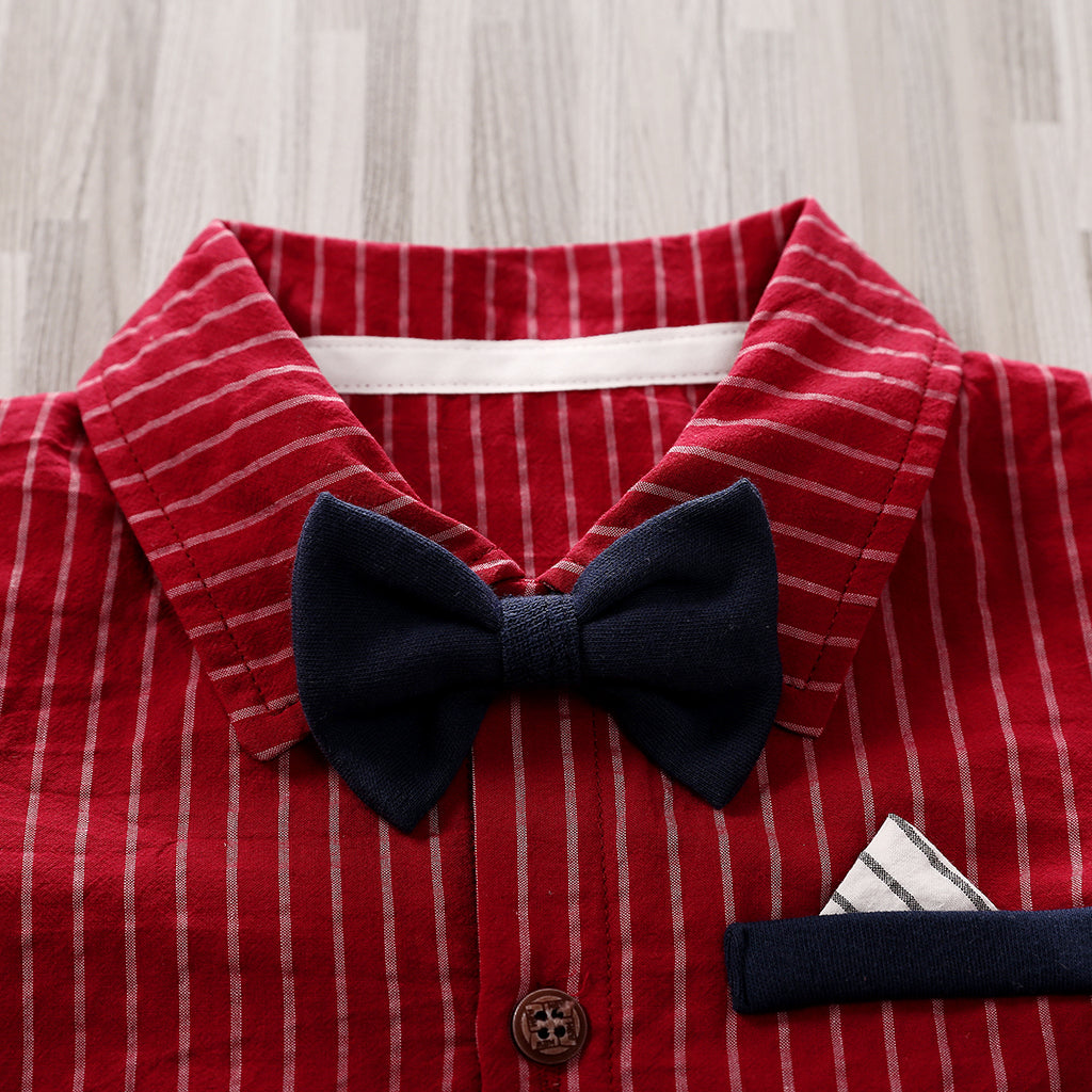A close-up of the Adorable 1-Piece Striped Infant Clothing Jumpsuit with bow tie and button-up front, showcasing its red and white stripes, navy blue bow tie, and pocket detail on breathable fabric laid on a light wooden surface.