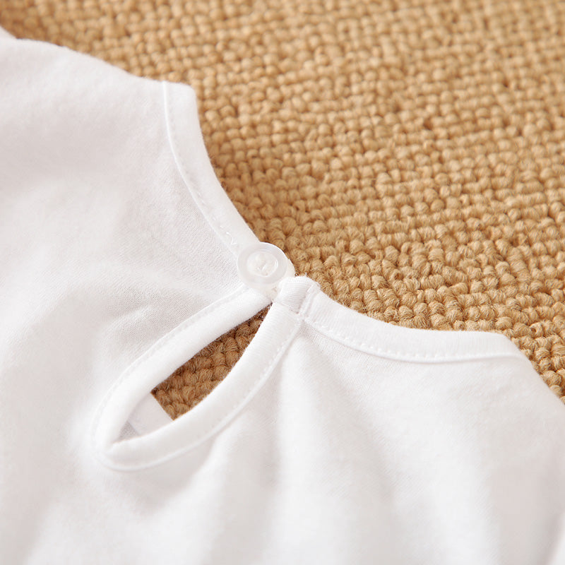Close-up of a white baby garment with a round neckline and keyhole back, laid on a beige woven surface—ideal for pairing with the Adorable 1-Piece Deer & Zebra Print Baby Romper with soft, breathable fabric and ruffle sleeves.