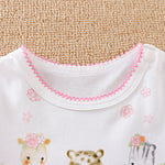 Soft white baby garment with pink zigzag trim and cute animal prints.