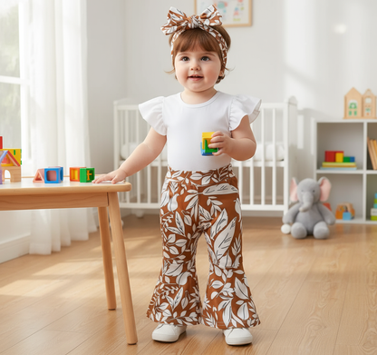 Trendy Baby Girl Outfits: 3-Piece Bell-Bottom Pants Set with White Bodysuit & Headwrap. Cute toddler wearing a stylish floral bell-bottom outfit, holding a toy in a bright playroom.