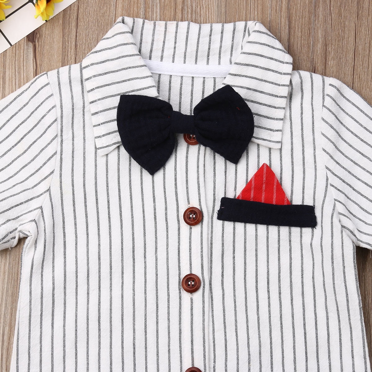 White striped baby shirt with black bow tie and red pocket square.