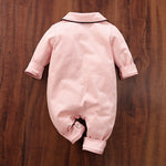 Back view of Pink baby cotton sleepwear on a wooden surface