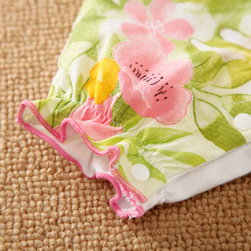 Floral fabric with pink and yellow flowers on romper bottom on a textured surface