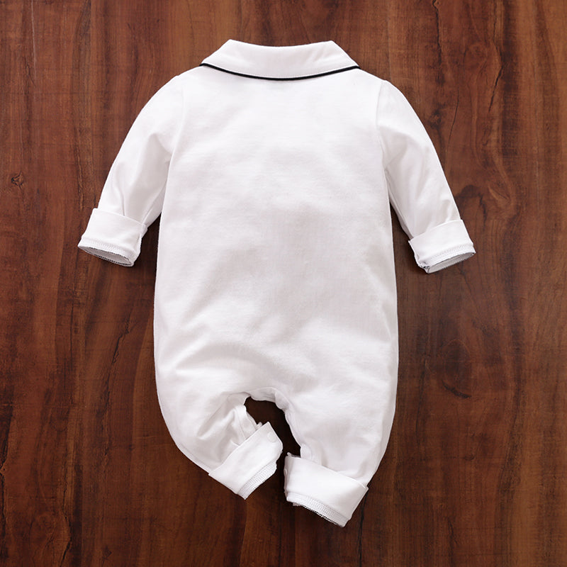 Back view of White baby sleepwear with black trim on a wooden surface