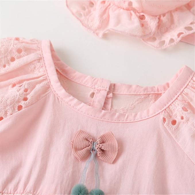 Pink baby dress with eyelet sleeves, a decorative bow, and matching hat.