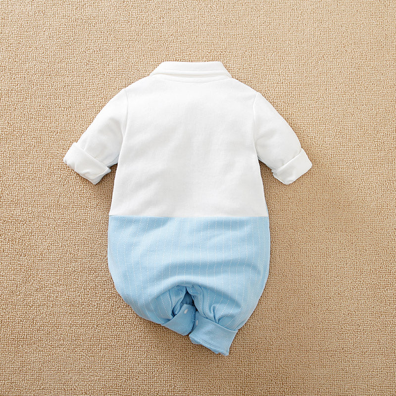 Back view of Baby jumpsuit with one piece white top and blue bottom on a beige surface