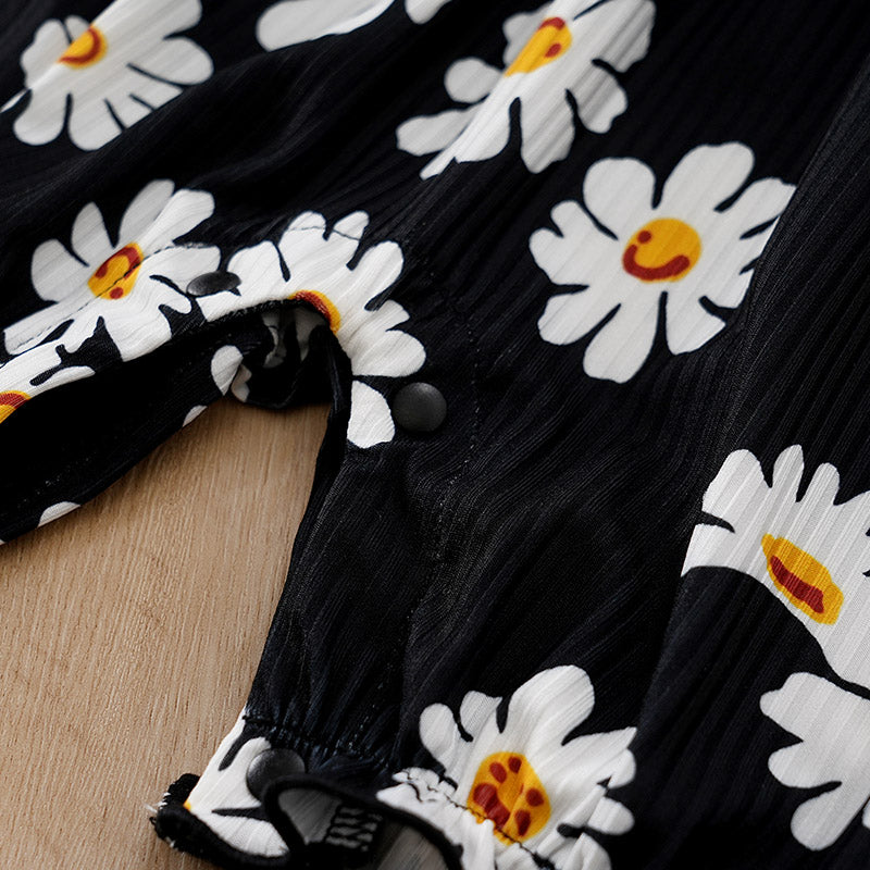 Sunshine Daisy Baby Romper Girls - Floral Summer Romper showing snap button closures on black fabric with cheerful white daisy print