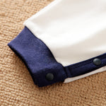 Soft Cotton Baby Dinosaur Jumpsuit With Cute Design, Long Sleeve & Easy Snap Closure close-up of snap buttons on navy cuff and white fabric
