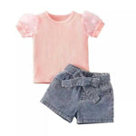 Set of cute kids clothing featuring a soft pink poke dot sleeve top and matching chic denim shorts, perfect for stylish summer adventures.