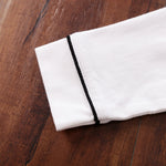White fabric with black trim on a wooden surface