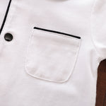 Close-up of a white shirt with a pocket and black trim.