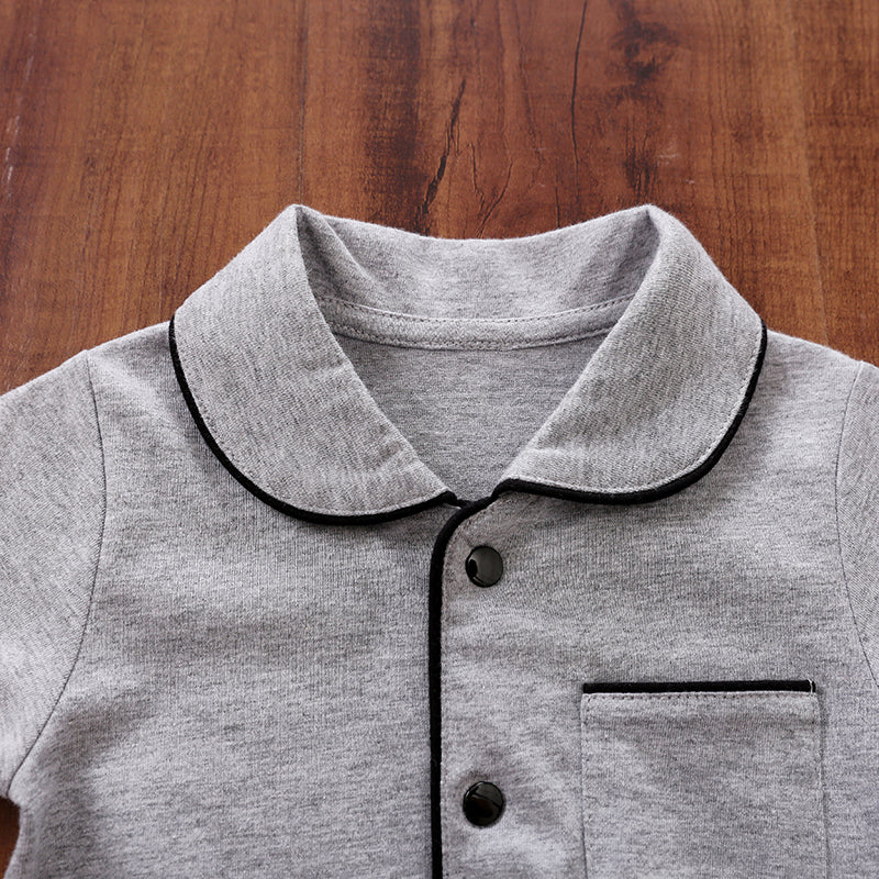 Gray cotton pajamas with black trim on a wooden surface