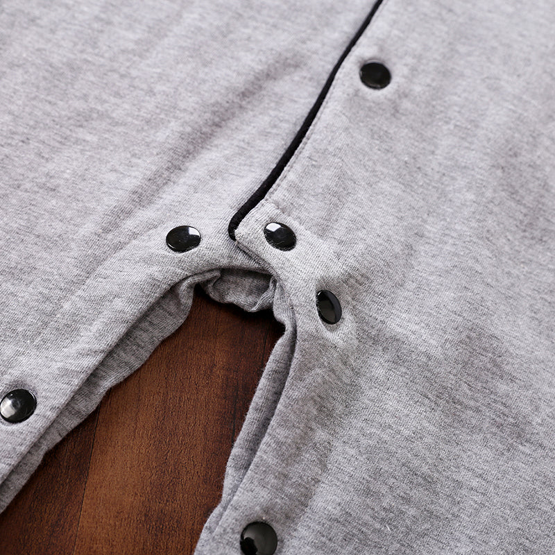 Gray cotton fabric with black snap buttons on a wooden surface