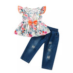 White floral peplum top with orange ruffled sleeves and distressed blue jeans.