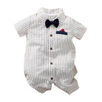 White and black striped baby jumpsuit with a dark blue bow tie and red pocket accent.