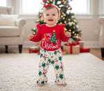 Adorable baby girl in a red bodysuit and festive pants, celebrating her first Christmas in style. Perfect for capturing memories in a baby girl's first Christmas outfit.