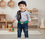 Child wearing Hushies Boys Lion Print Long Sleeve Shirt, happily standing in a playroom, showcasing comfort and style.